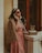 a woman in a pink dress talking on a phone