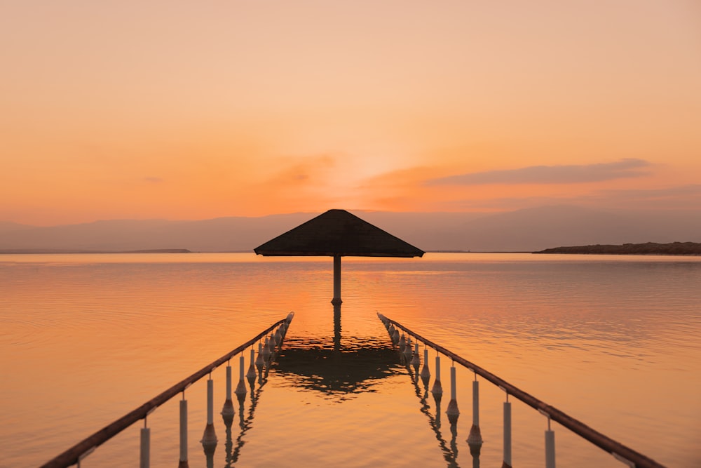 a dock with a gazebo in the middle of a body of water