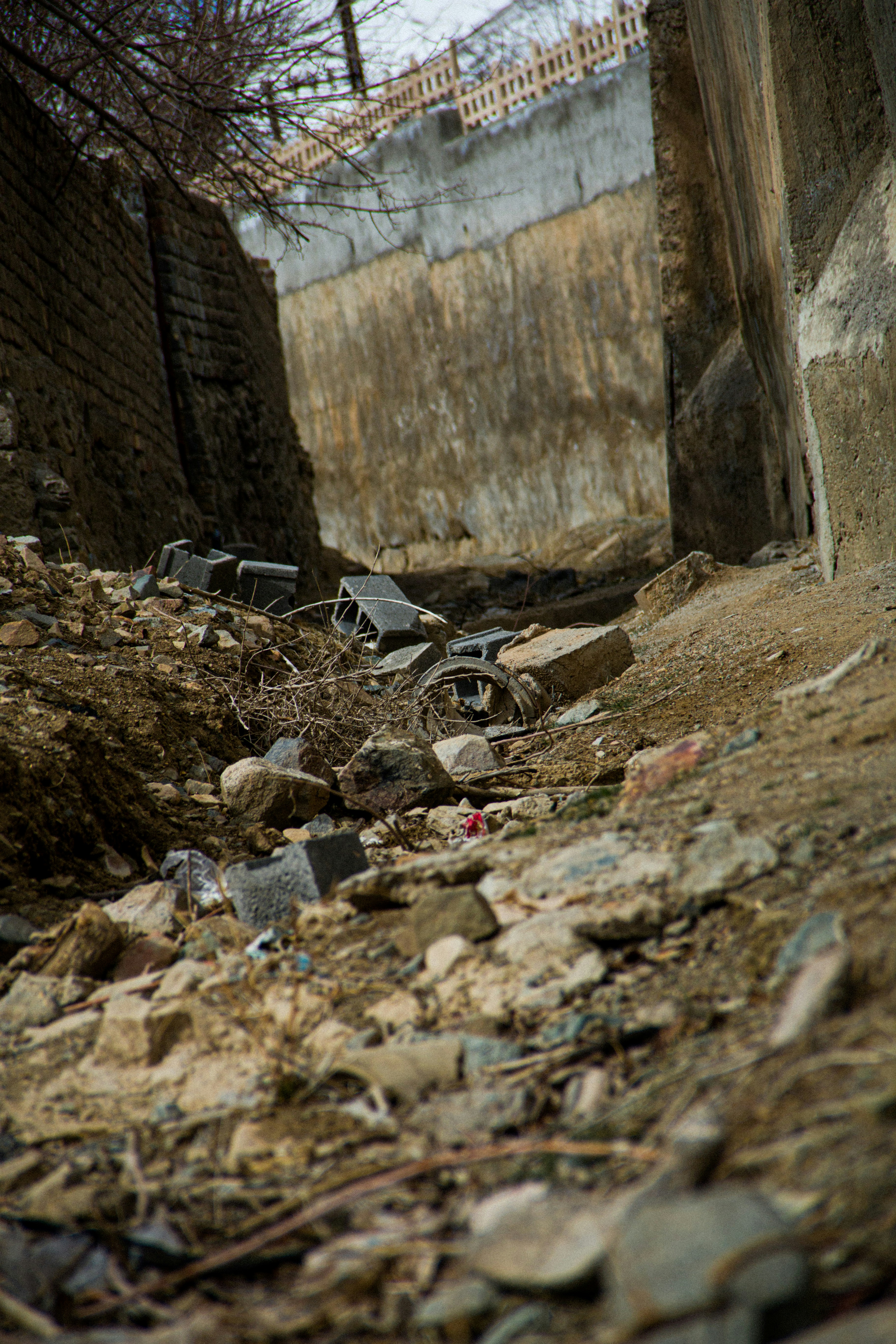 a dirt road with rocks and debris on the ground