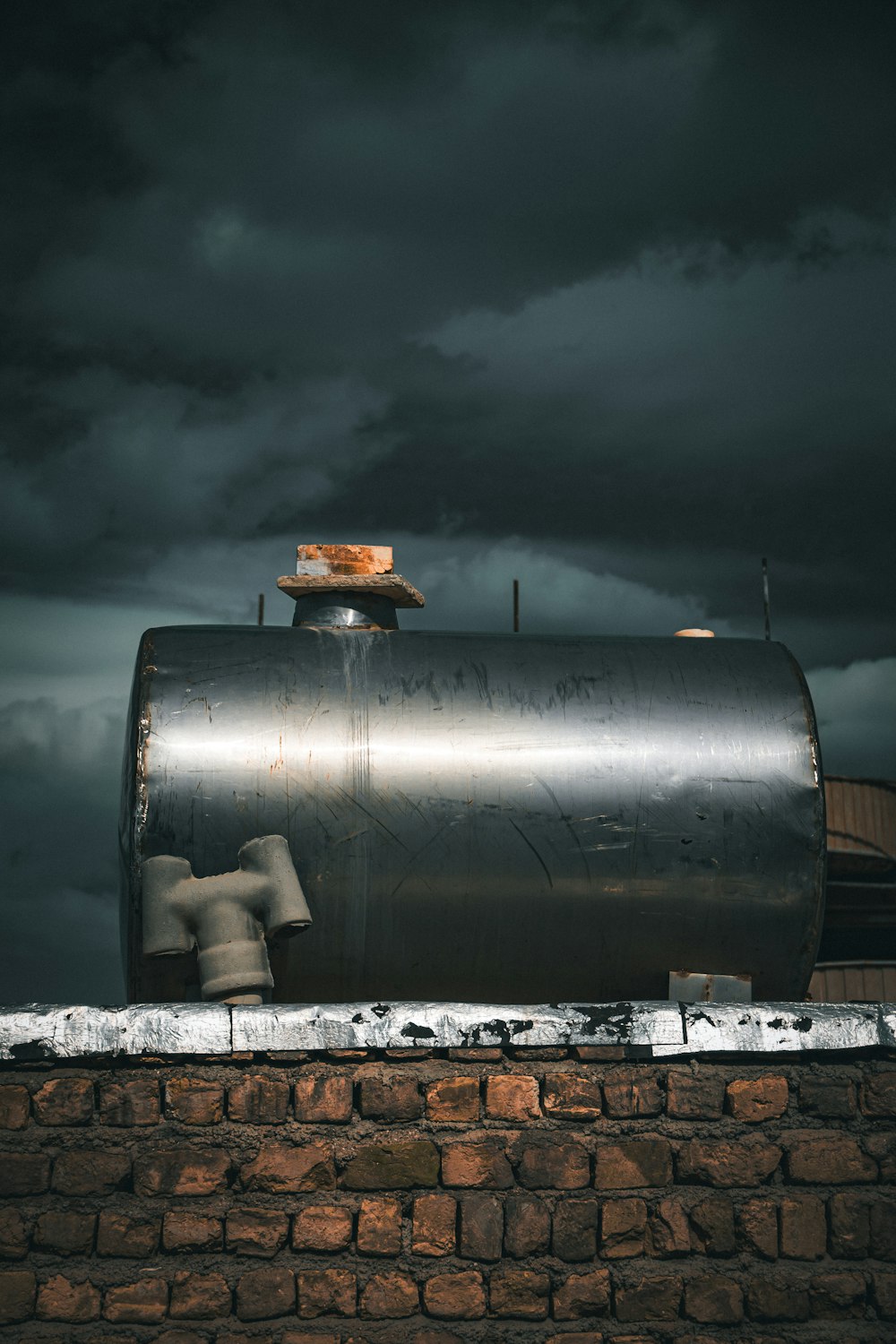 a large metal tank sitting on top of a brick wall