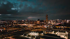 The Houston skyline and its freeway interchanges lit up at night under heavy clouds