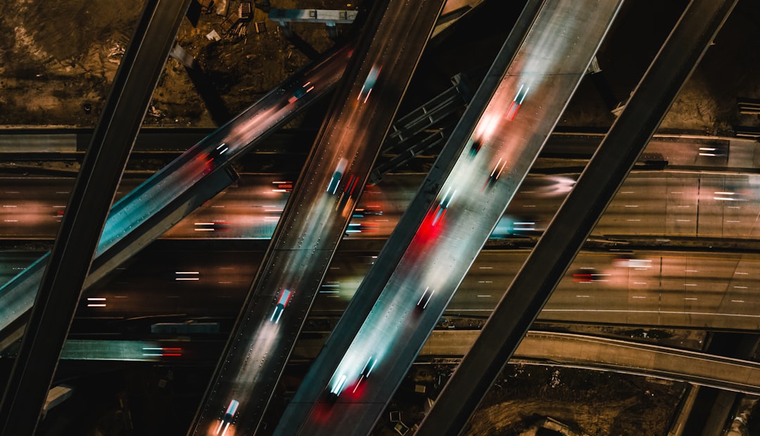 an aerial view of a freeway at night, Top down shot of cars passing on overpasses