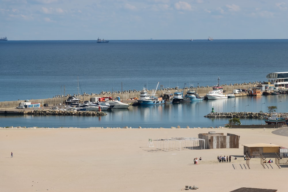 a harbor filled with lots of boats on top of a sandy beach