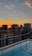 Sunset view from a luxury penthouse balcony overlooking the city skyline.