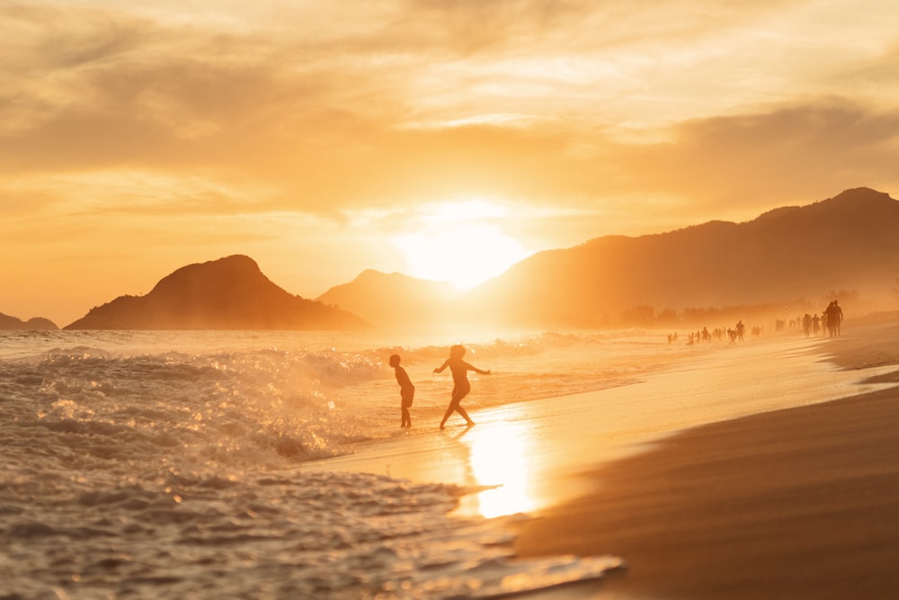 a couple of people riding surfboards on top of a wave