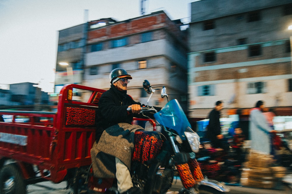 a man riding on the back of a motorcycle down a street