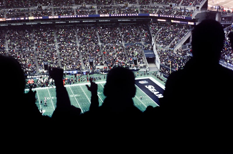 A crowd of people watching a football game in a packed stadium