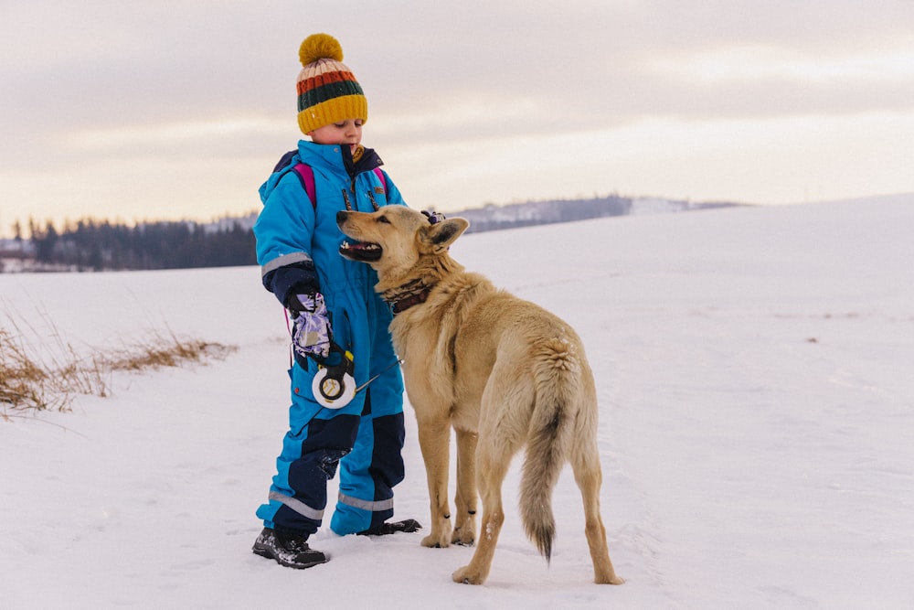 a man and a dog standing in the snow