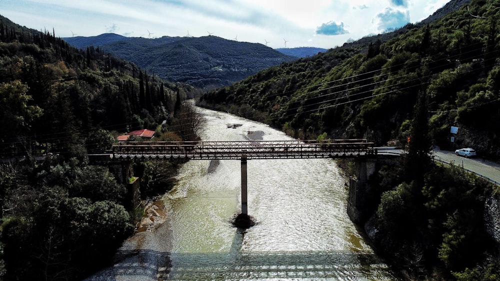 a bridge over a river surrounded by mountains