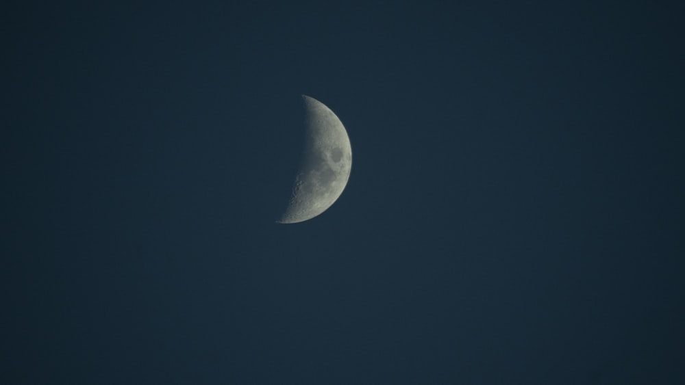 a half moon in the sky with a dark background