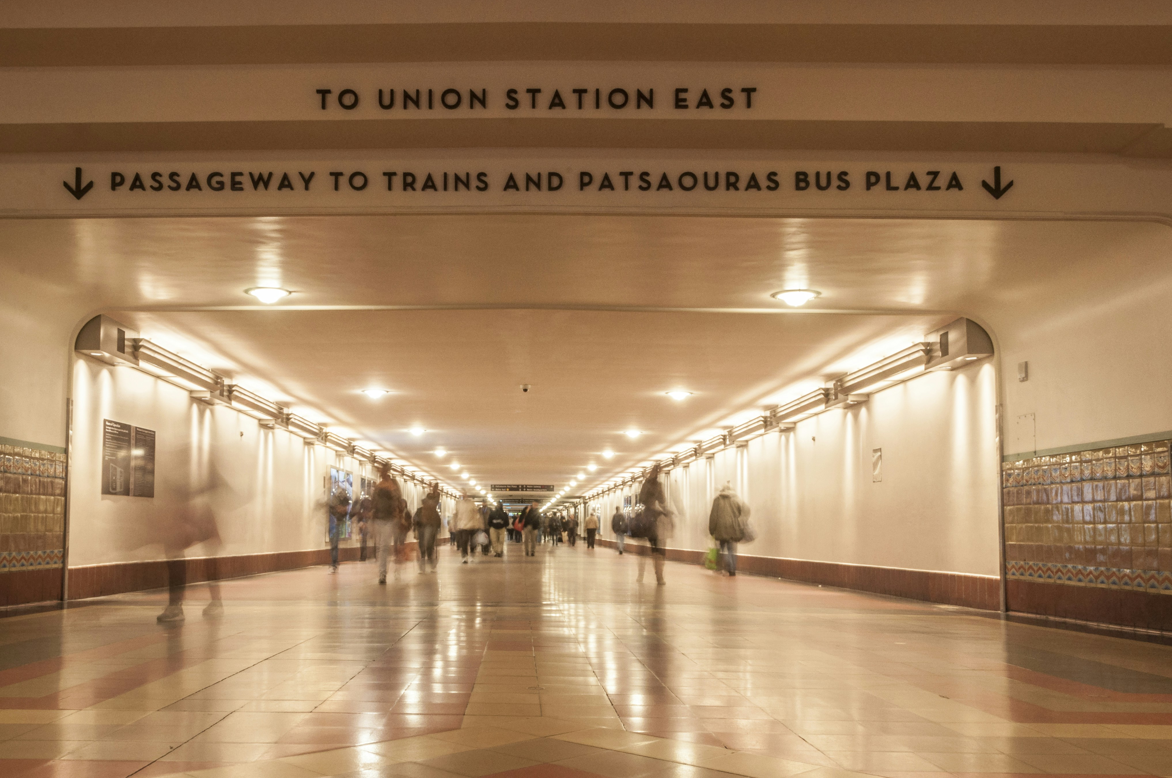 a group of people walking down a long hallway