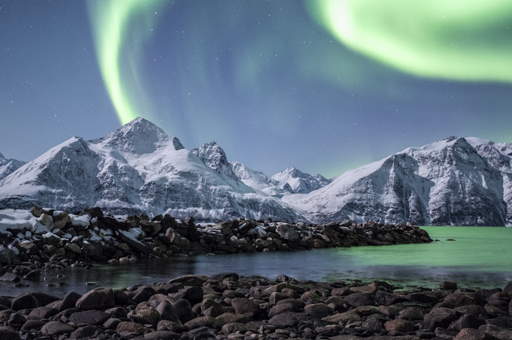 a green and white aurora above a mountain range