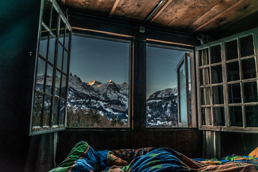 a bedroom with a view of the mountains outside the window