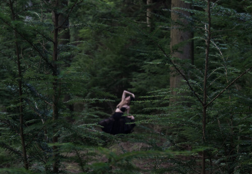 a person in the middle of a forest doing a handstand