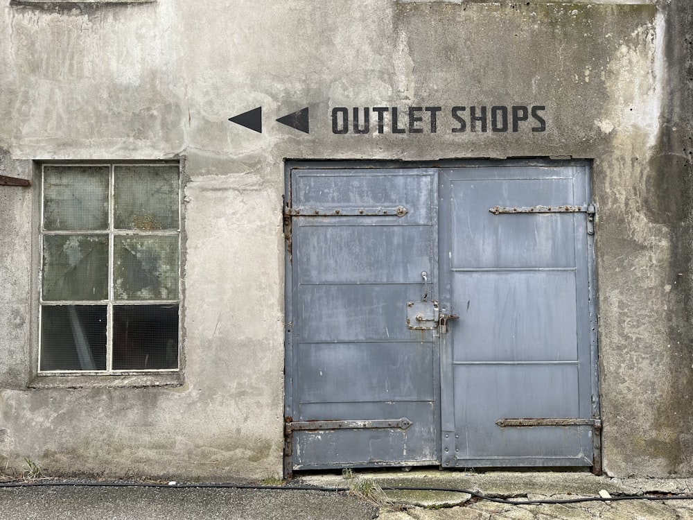an old building with two blue doors and a sign that says outlet shops