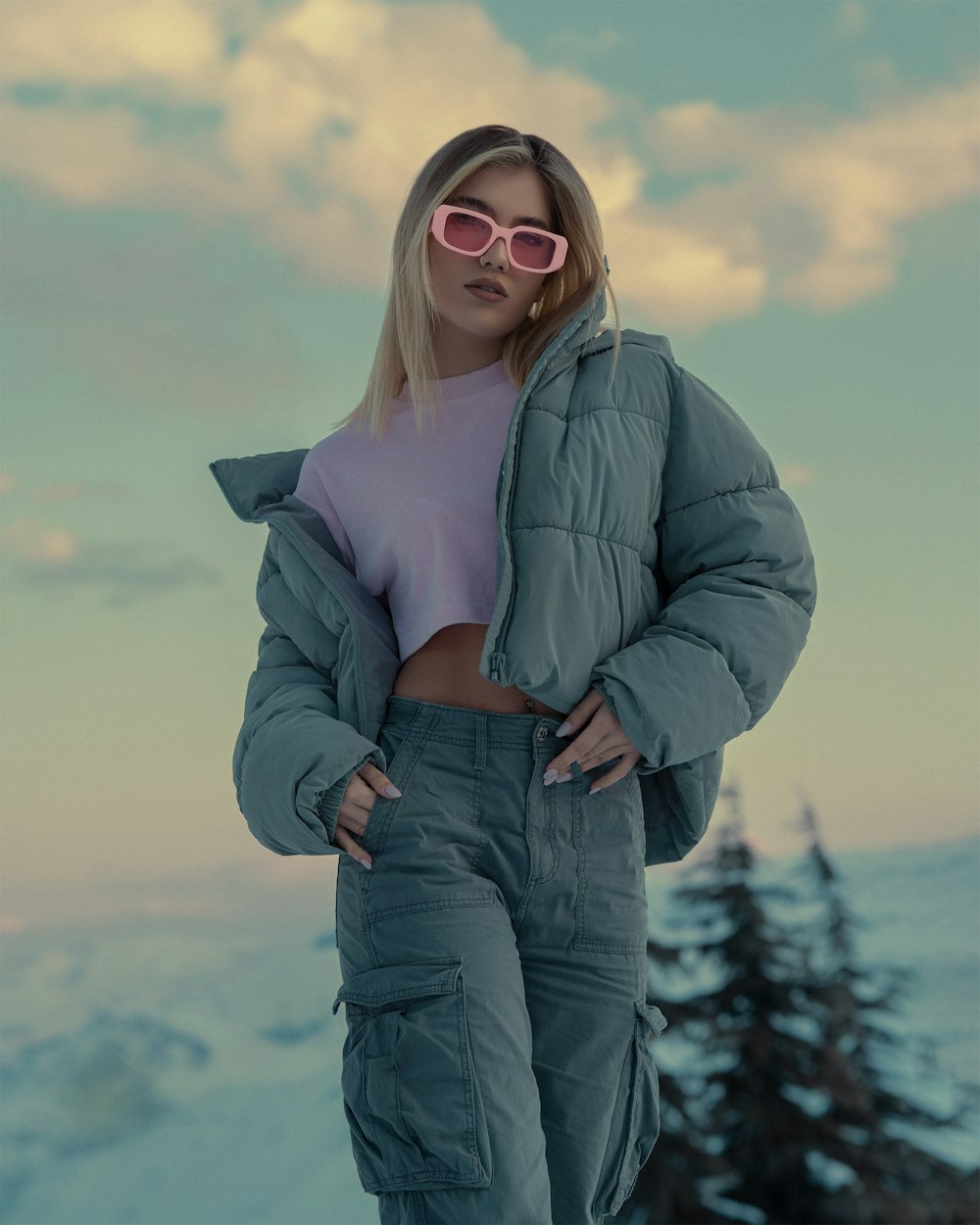 a woman in a puffy jacket and pink sunglasses