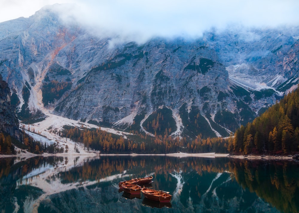 a mountain range is reflected in the still water of a lake