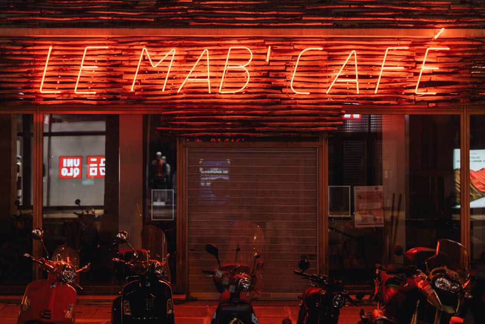 a neon sign that reads le mad cafe