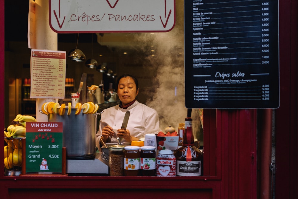 a man in a white shirt and tie behind a counter