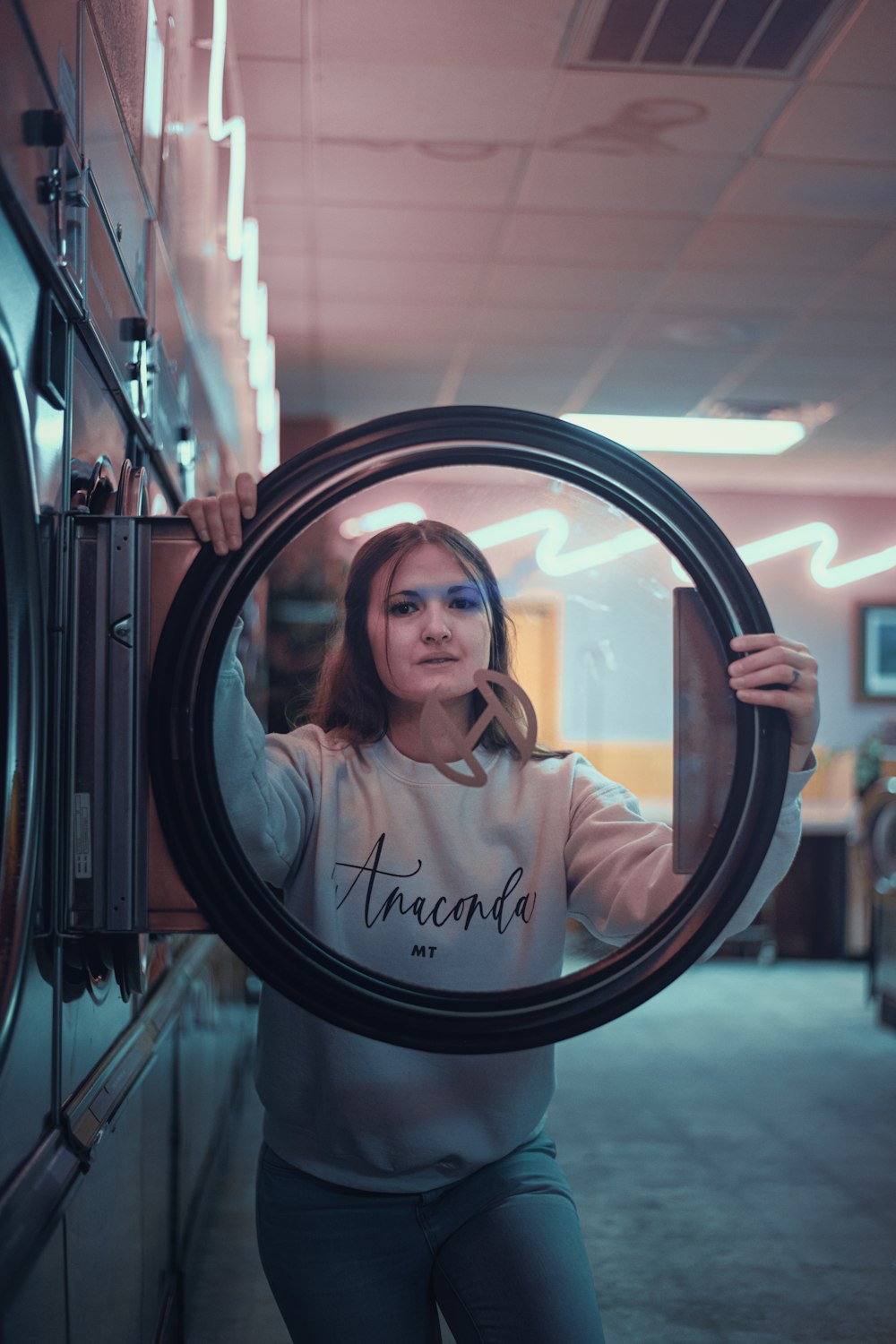 a woman is holding a mirror in front of her face