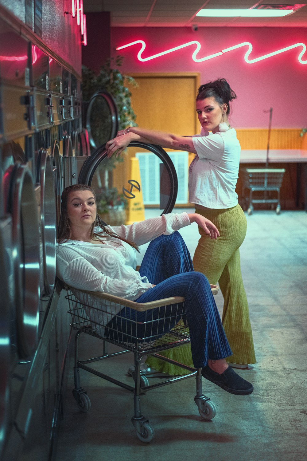 a woman pushing a shopping cart next to another woman