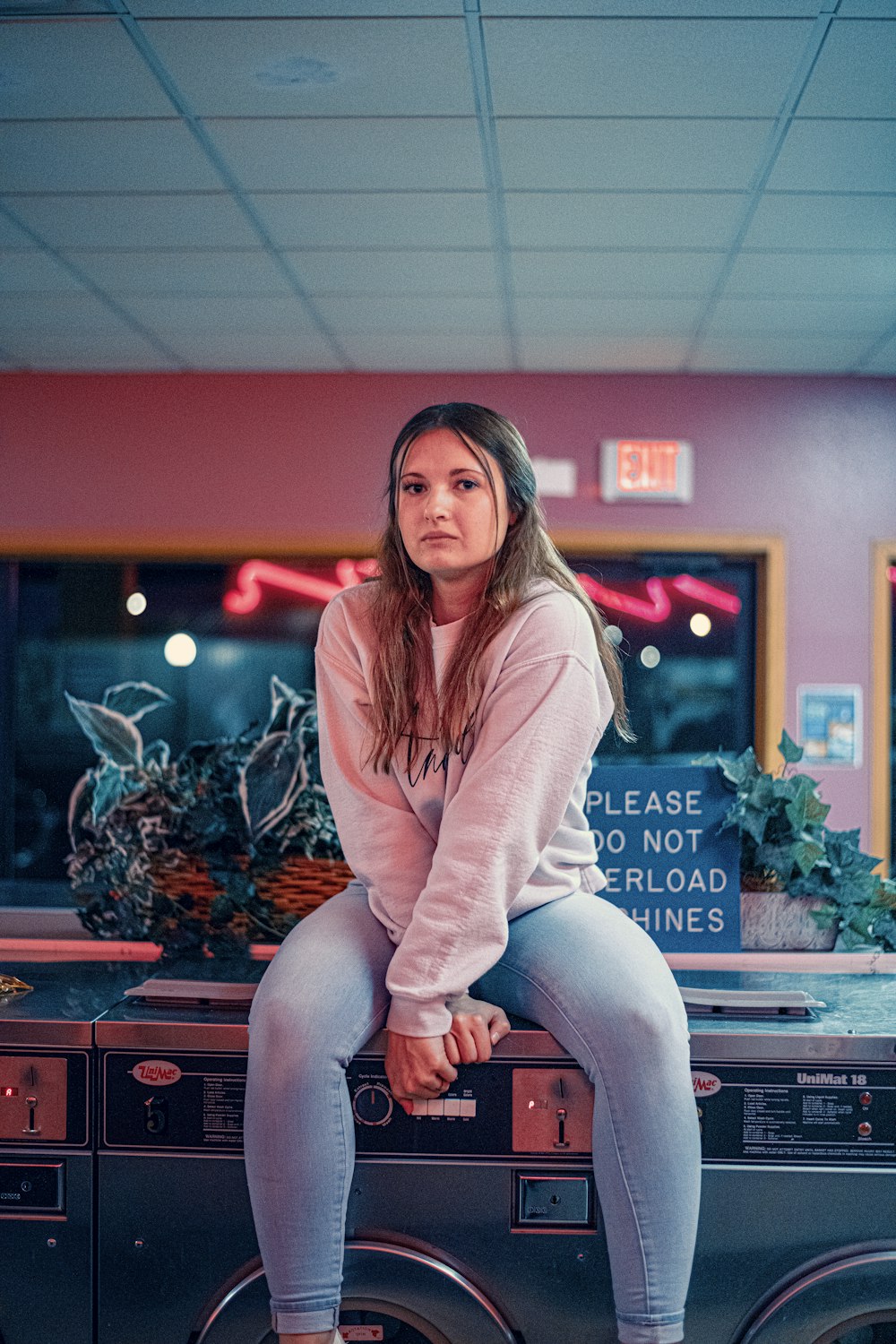 a woman sitting on top of a washing machine