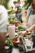Group of millennials participating in an eco-friendly workshop with plants around.