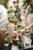 A group of diverse volunteers working together in a community garden, planting flowers and vegetables.