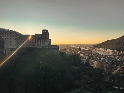 Fantasy adventure game showing a hero standing before a glowing castle at sunset.