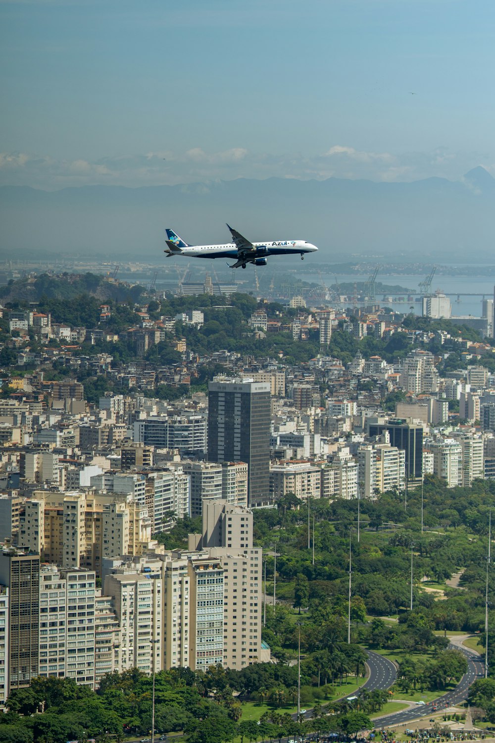 a large jetliner flying over a large city