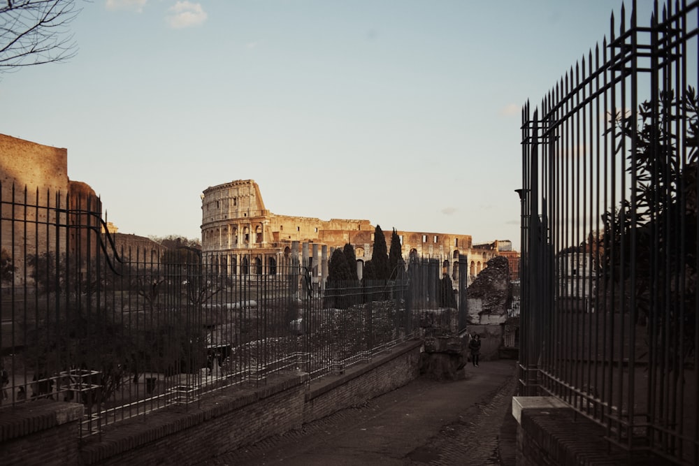 a fenced in area with a building in the background