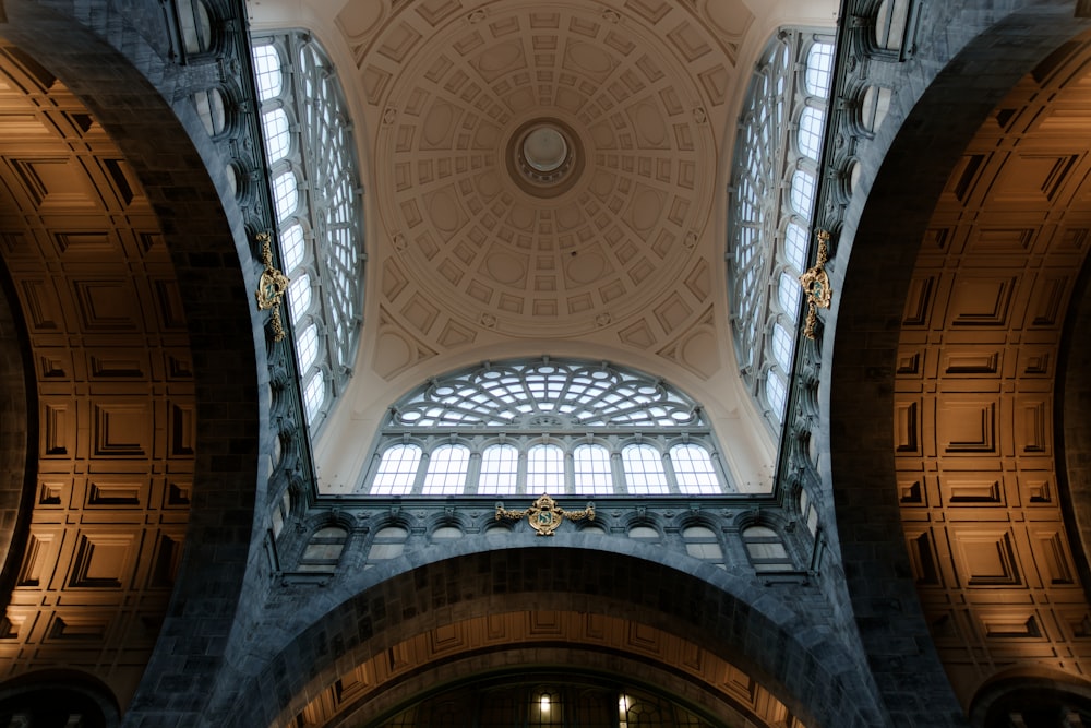 the ceiling of a large building with a clock on it