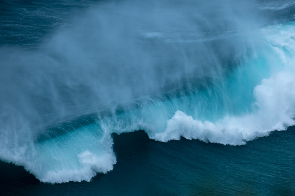 a large wave breaking over the top of the ocean