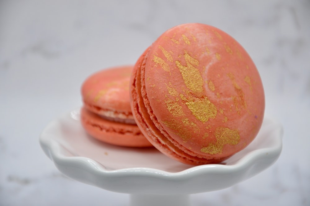 two pink macaroons on a white plate