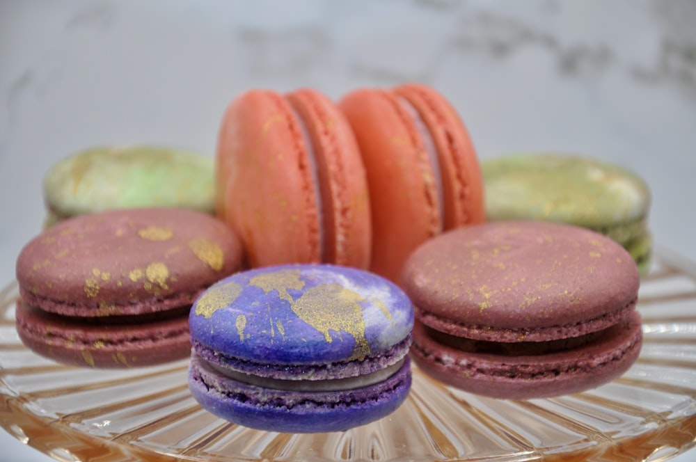 a glass plate topped with macaroons on top of a table