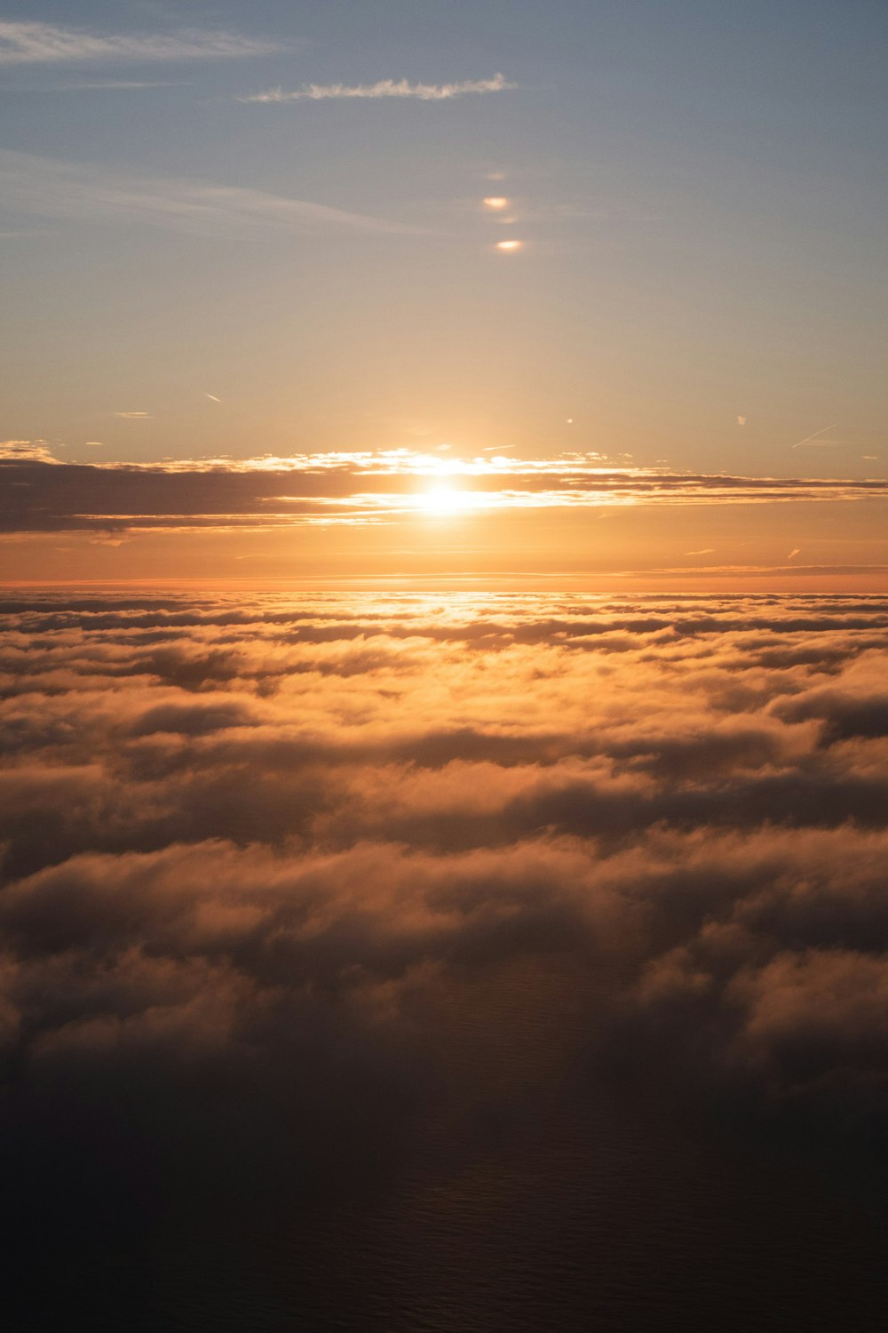 the sun is setting over the clouds in the sky