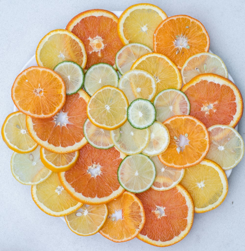 un plato blanco cubierto con rodajas de naranjas y pepinos