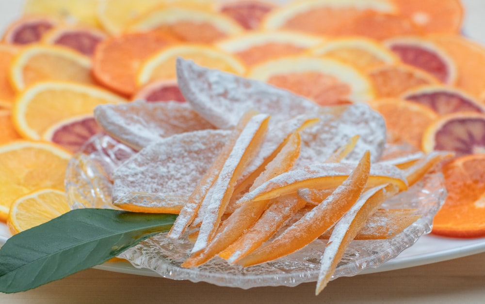 ein weißer Teller mit Orangenscheiben, die mit Zucker überzogen sind