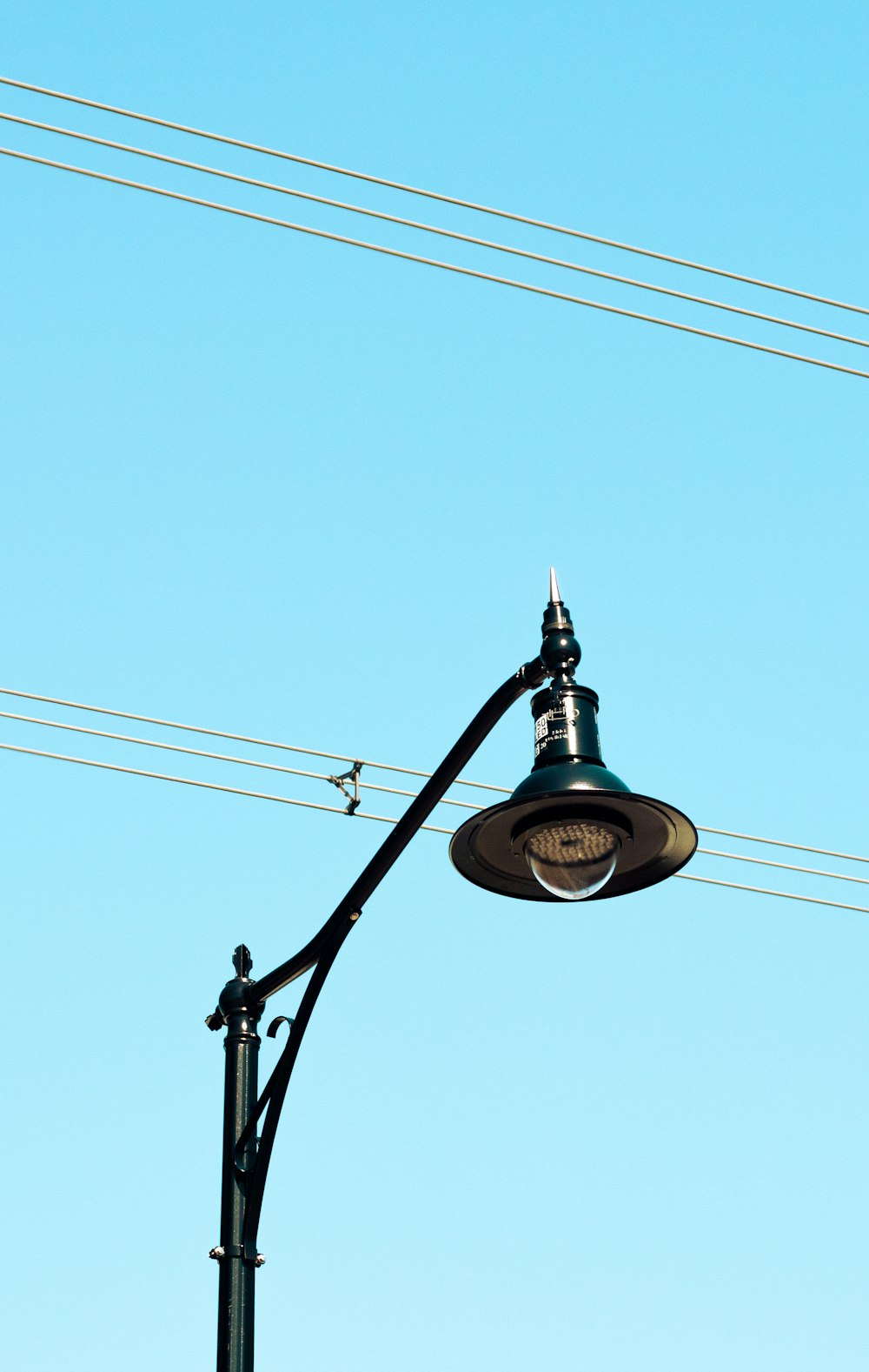 a street light on a pole with power lines in the background