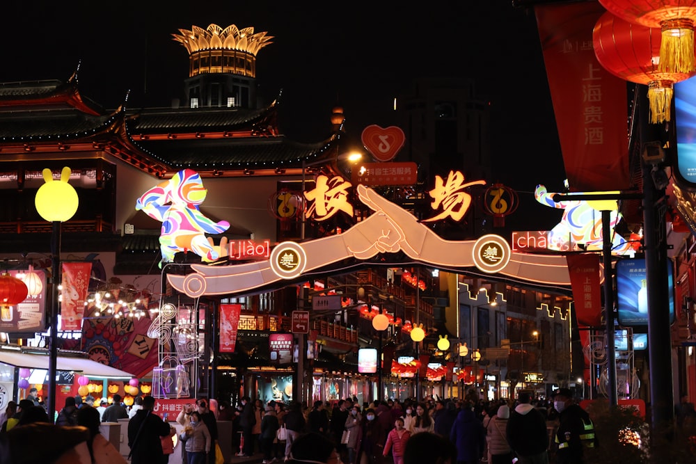 a crowd of people walking down a street at night