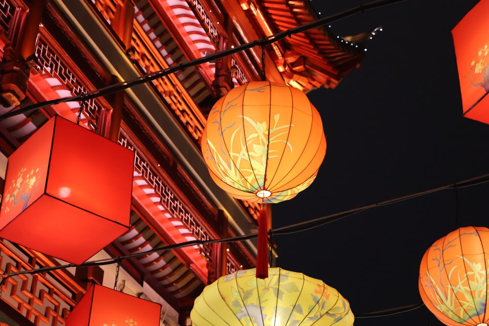 a group of red and yellow lanterns hanging from a building