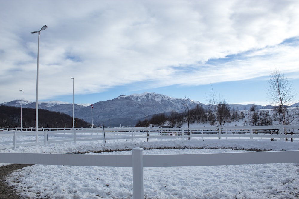 a snow covered field with mountains in the background