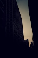 A delicate black-and-white sketch of a cityscape at dusk, emphasizing light and shadow.