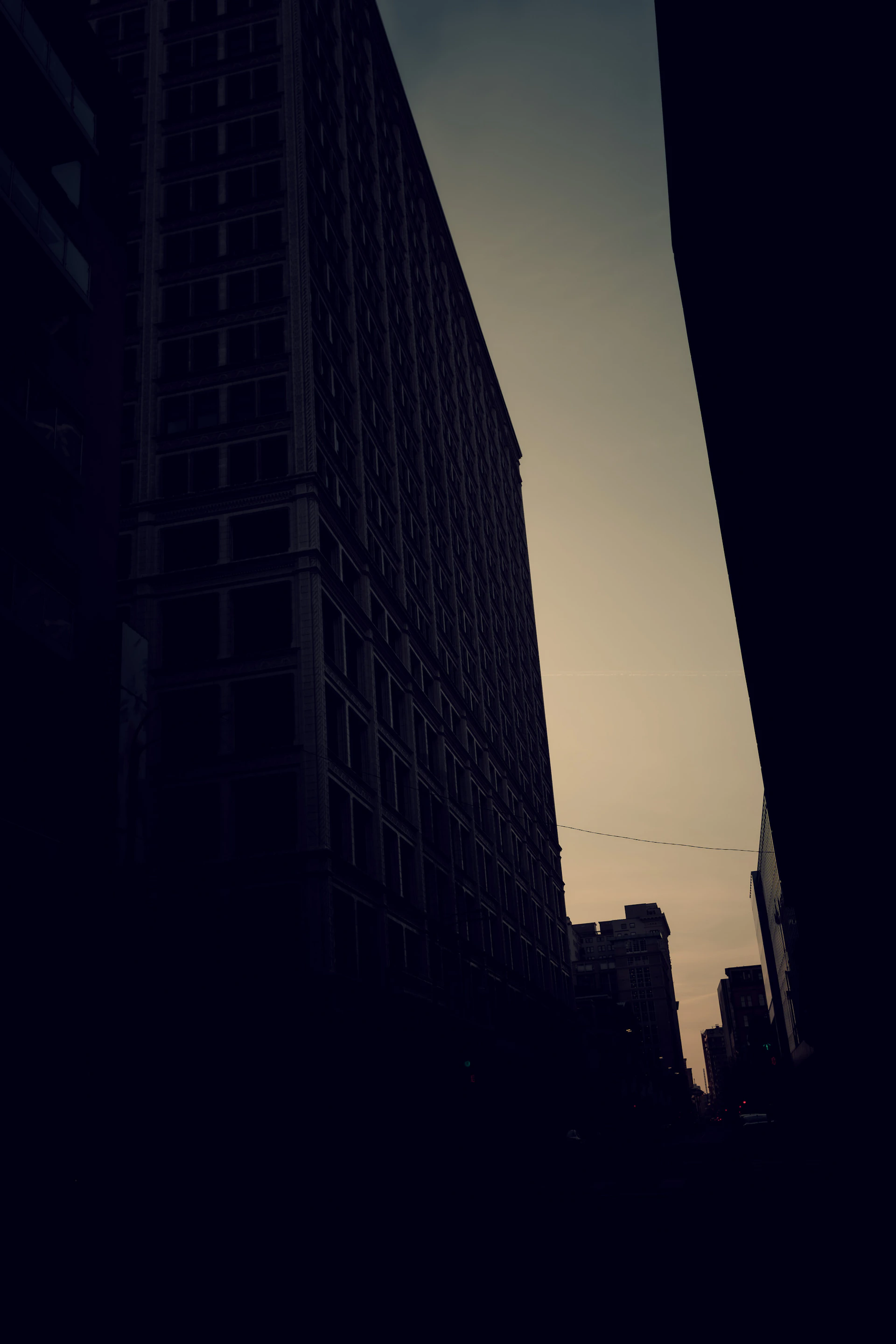 A striking large-format photograph capturing the delicate interplay of light and shadow on an urban landscape at dusk.