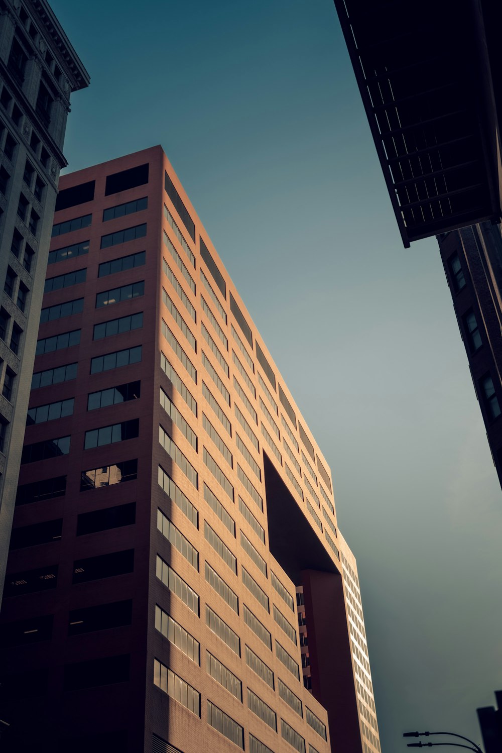 a tall brown building with a sky background