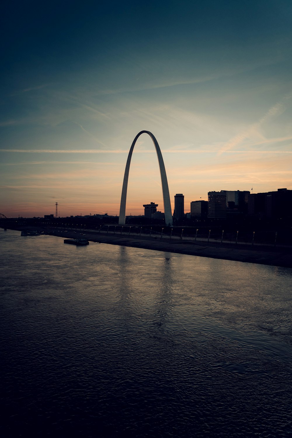 the st louis arch is silhouetted against the sunset