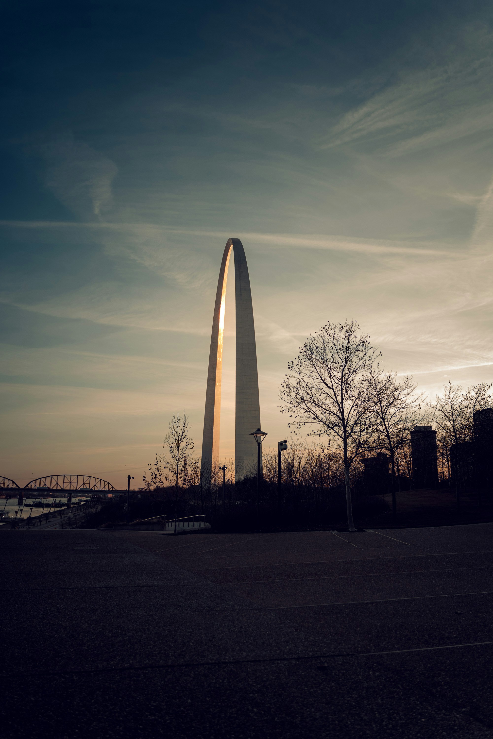the washington monument is silhouetted against a cloudy sky