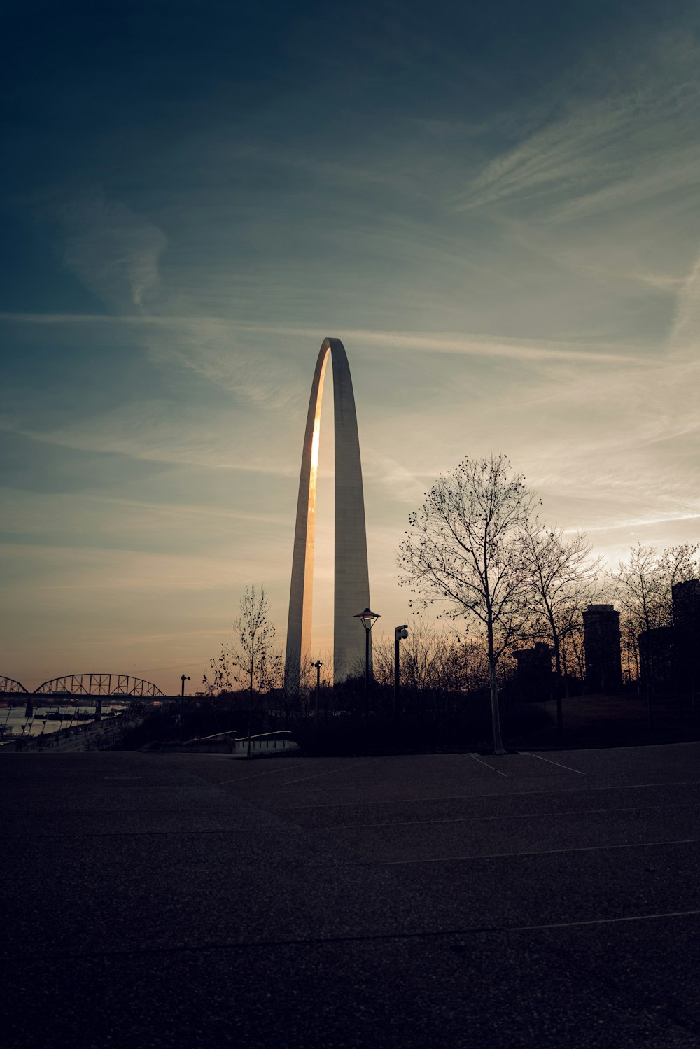 the washington monument is silhouetted against a cloudy sky