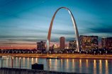 the st louis arch is lit up at night