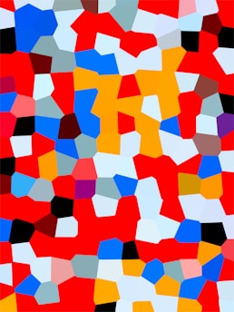 A vibrant mosaic of irregular, colored shapes scattered across the canvas. The pattern includes bright reds, blues, oranges, whites, and blacks, creating a dynamic and colorful abstract design.